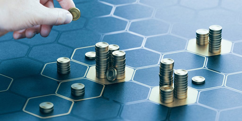 Human hand stacking coins over a black background with hexagonal golden shapes. Concept of investment management and portfolio diversification. Composite image between a hand photography and a 3D back